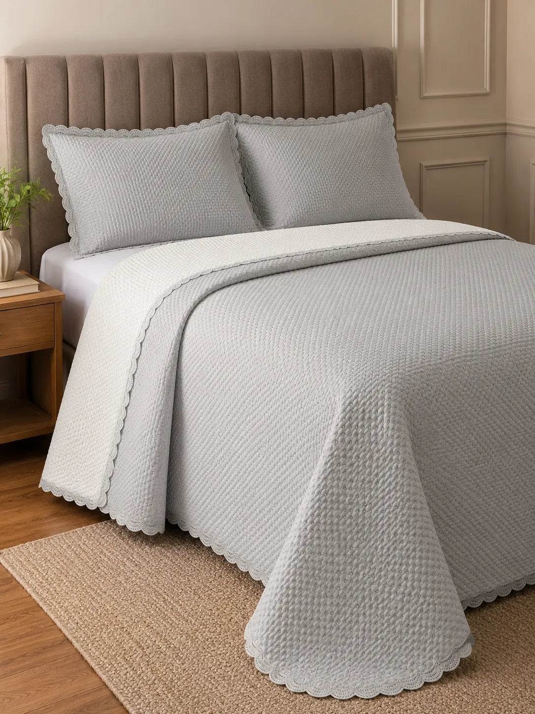 Cobre-leito matelassê cinza claro com verso branco na cama de casal