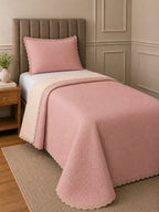Cobre-leito matelassê rosa com verso bege na cama de solteiro